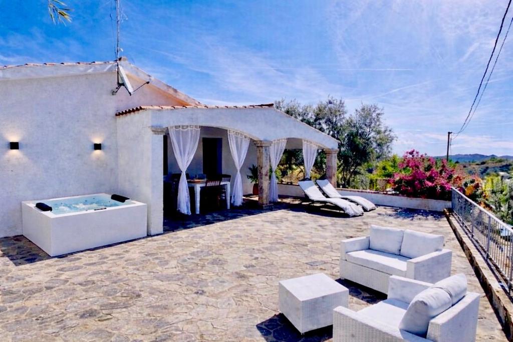 a patio with white furniture and a tent at International House San Teodoro in San Teodoro
