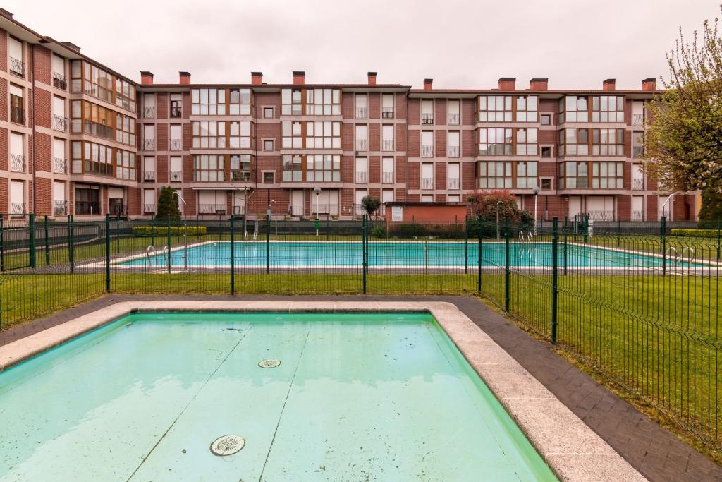 an empty swimming pool in front of a building at Piso con piscina in Bádames