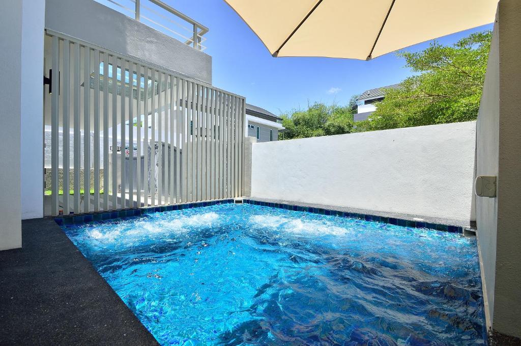 a swimming pool in the floor of a house with an umbrella at Plumeria Luxury Service Villa in George Town