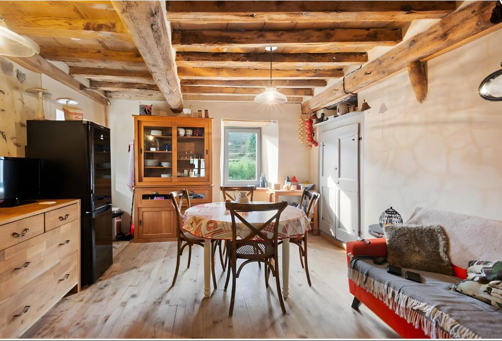 a kitchen and living room with a table and a couch at Maison du Pâtre in Urbanya