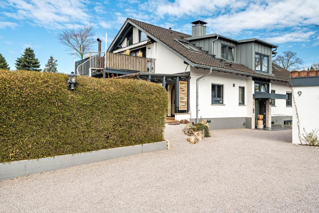 a white house with a hedge in front of it at Schwarzwald Glück in Bühl