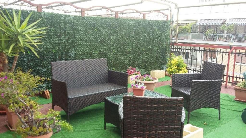 a patio with two chairs and a table with plants at Bed and Breakfast sapore da mare in Lido di Ostia