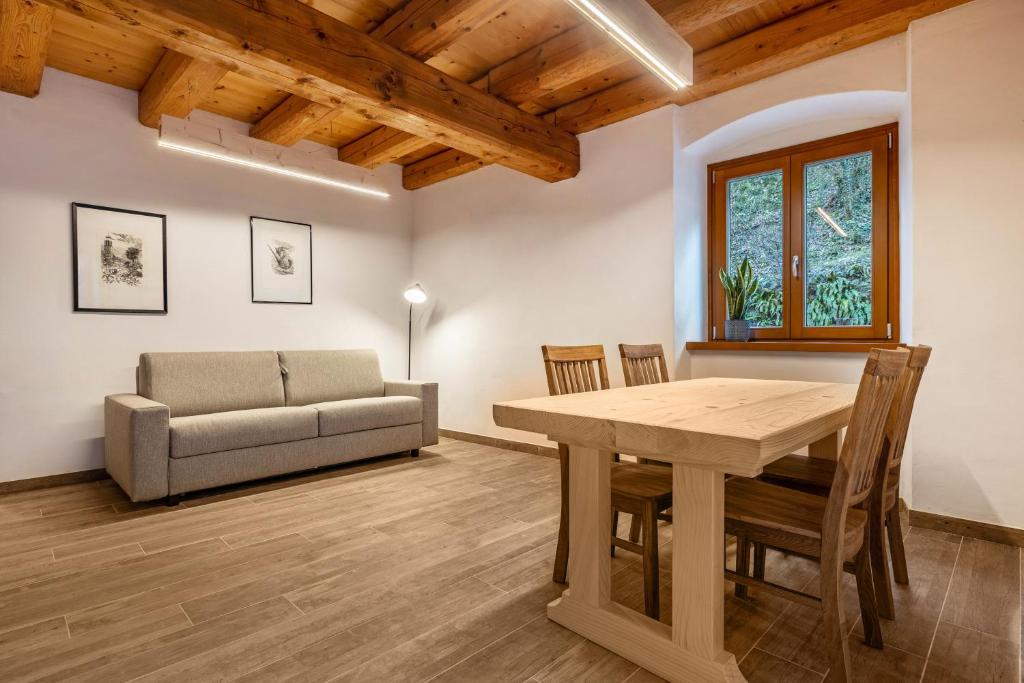 a living room with a table and a couch at Casa al Mulino 2 in Tenno