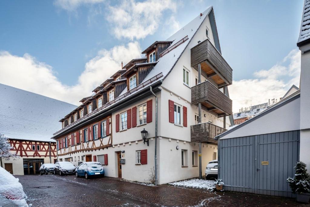 a white building with red windows and a parking lot at Alte Schule in Münsingen