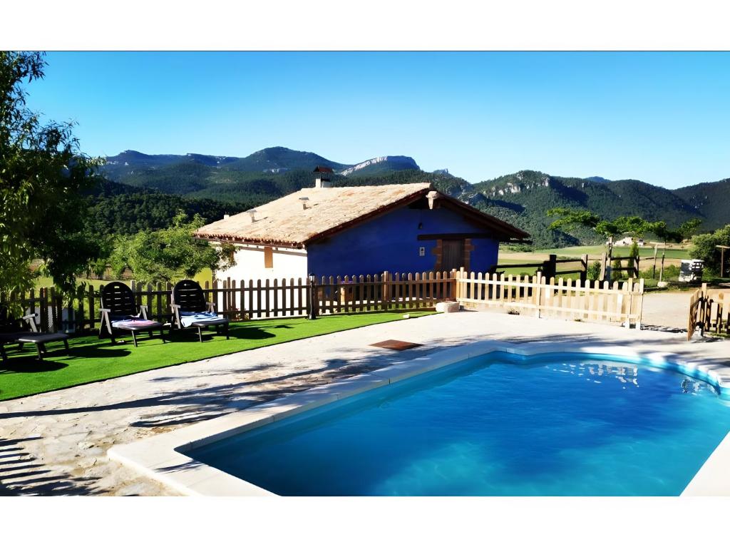 a swimming pool in front of a house at La Sala in Peñarroya de Tastavins