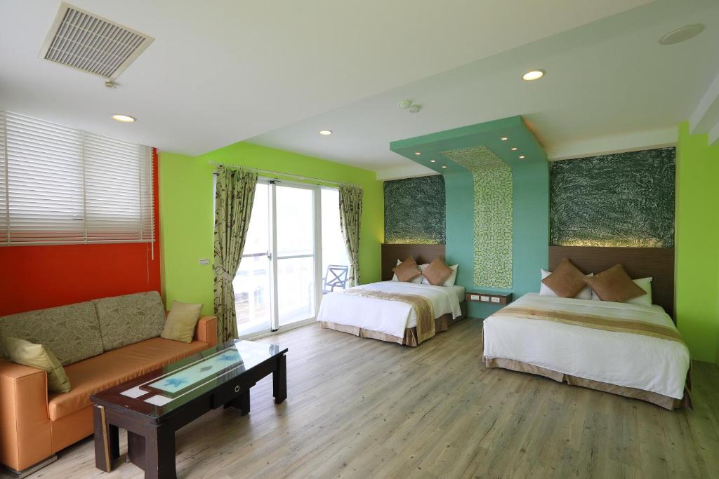 a hotel room with two beds and a couch and a table at Hang Hai B&amp;B in Eluan