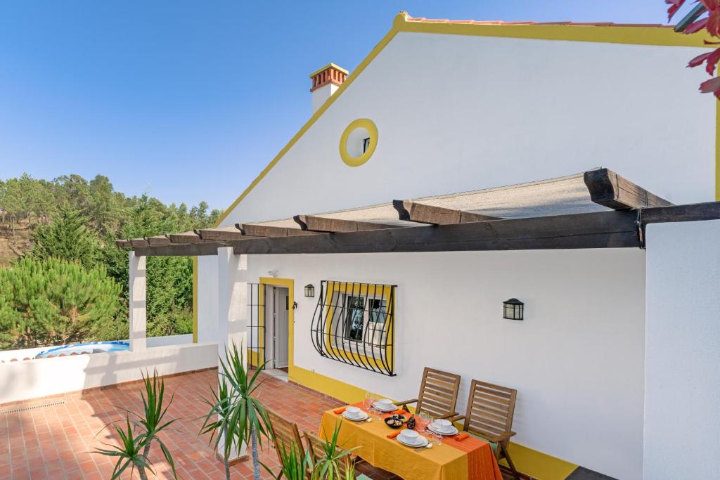 a white house with a table and chairs on a patio at Alquimia, Alchemy, Alchimie in São Luis