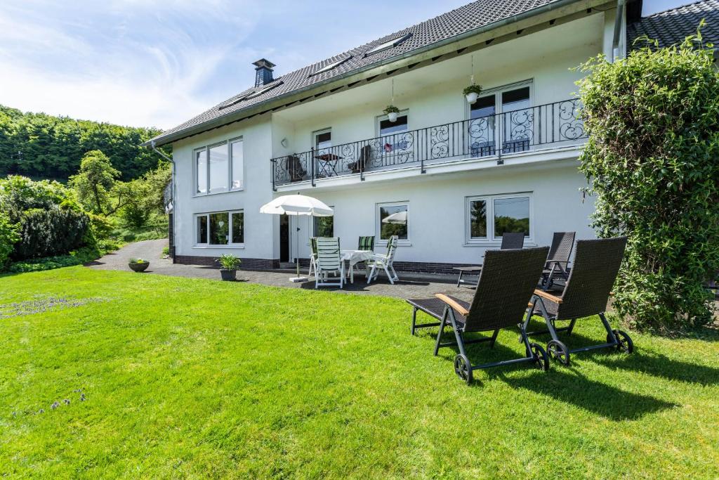 an exterior view of a house with chairs on the lawn at Ferienwohnung Auszeit Sauerland in Meinerzhagen