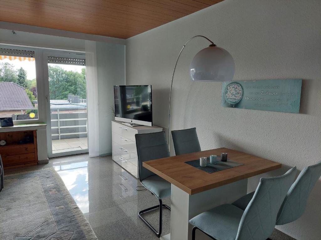 a dining room with a table and chairs and a television at Ferienwohnung Sander mit Innenpool in Möhnesee