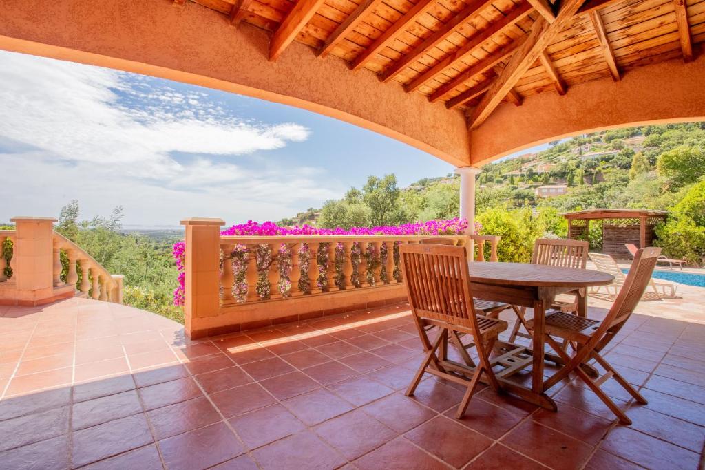 a patio with a table and chairs and a view at Villa Lucio in La Londe-les-Maures