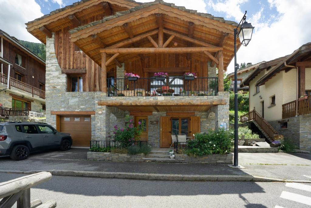 a house with a wooden roof and a balcony at Chez Stephane et Estelle in Villarodin-Bourget