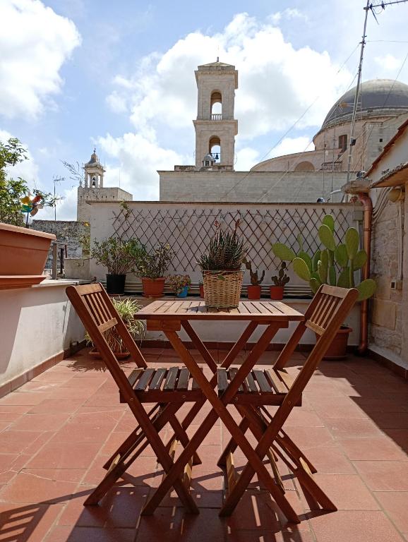 ein Holztisch und zwei Stühle auf einer Terrasse in der Unterkunft Dimora Giulia Superba in Terlizzi