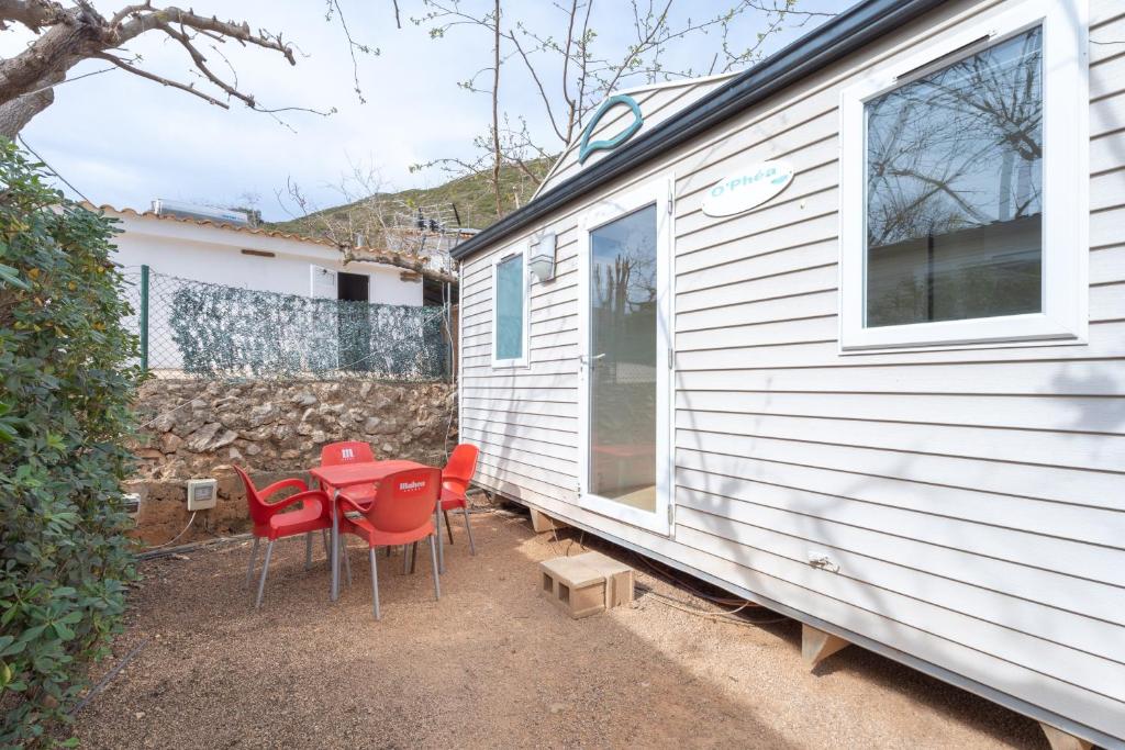 a group of red chairs and a table next to a house at Falaguera Bungalow 2 in Bárig