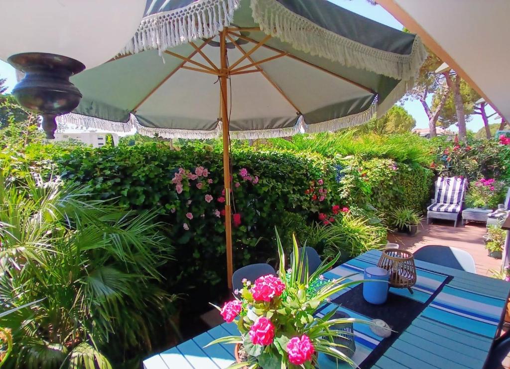 an umbrella sitting on top of a table with flowers at Des vacances de rêve à Mandelieu in Mandelieu-La Napoule