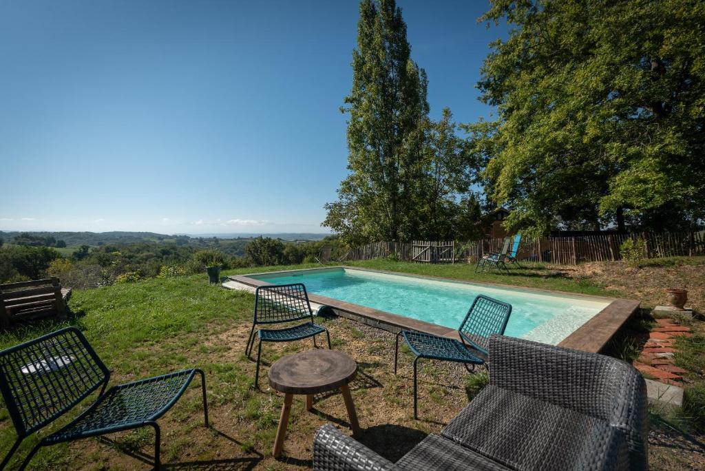 a group of chairs and a swimming pool at Maison de vacances La Toumet in Malabat