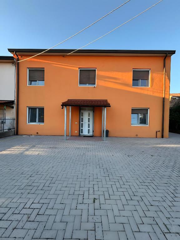 an orange building with a driveway in front of it at Casa Domus Oppiorum in Ca degli Oppi