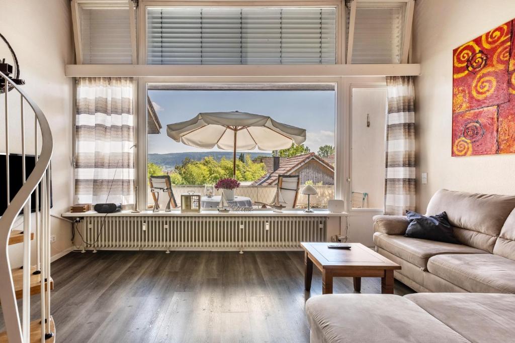 a living room with a couch and a large window at Seesucht in Gaienhofen