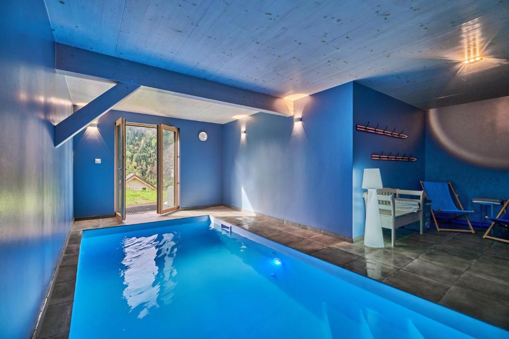 a swimming pool in a house with blue walls at L'Ecrin de Venosc piscine privée in Les Deux Alpes