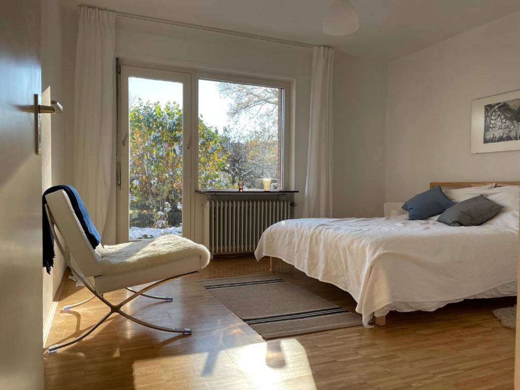 a bedroom with a bed and a chair and a window at Haus am Reithagen in Hofgeismar