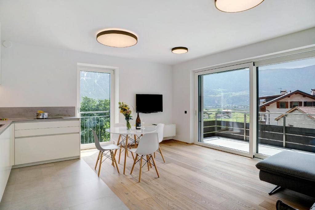 a kitchen and living room with a table and a large window at Haus Weinblick Apt 5 in Magrè allʼ Adige