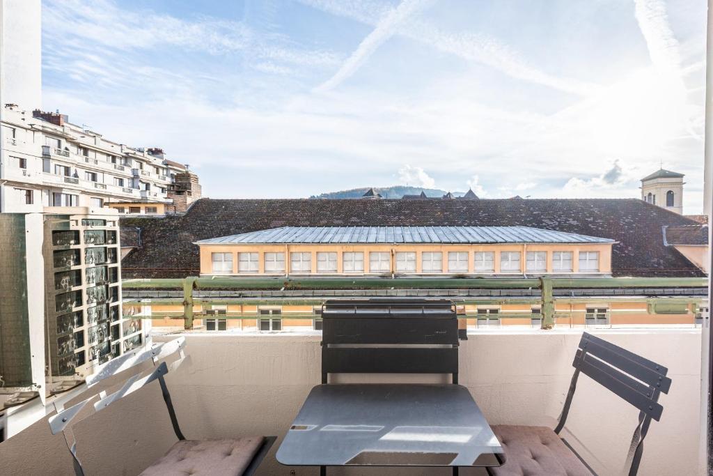 a balcony with a table and two chairs on a building at Annecy - Le 10 in Annecy