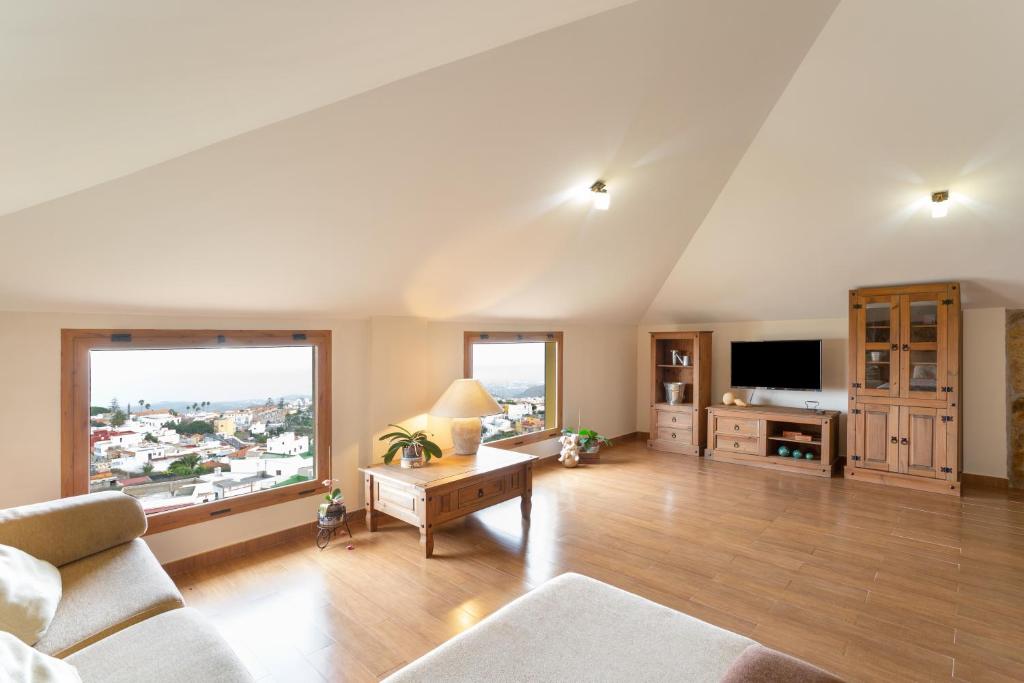 a large living room with a couch and a tv at Casa Yaraina in Firgas