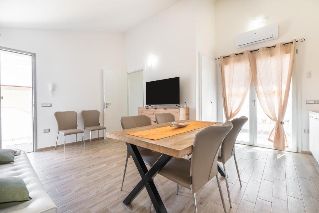 a dining room with a wooden table and chairs at Casa Vacanze Alba Mar in SantʼAntìoco