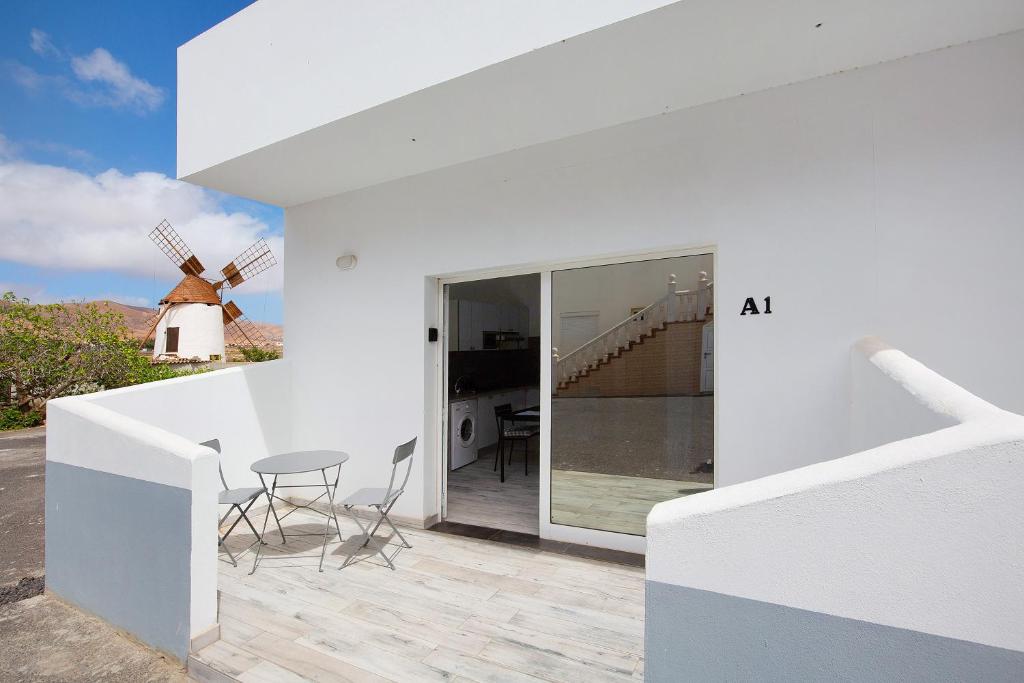 a white house with a windmill in the background at La Corte A1 in Antigua