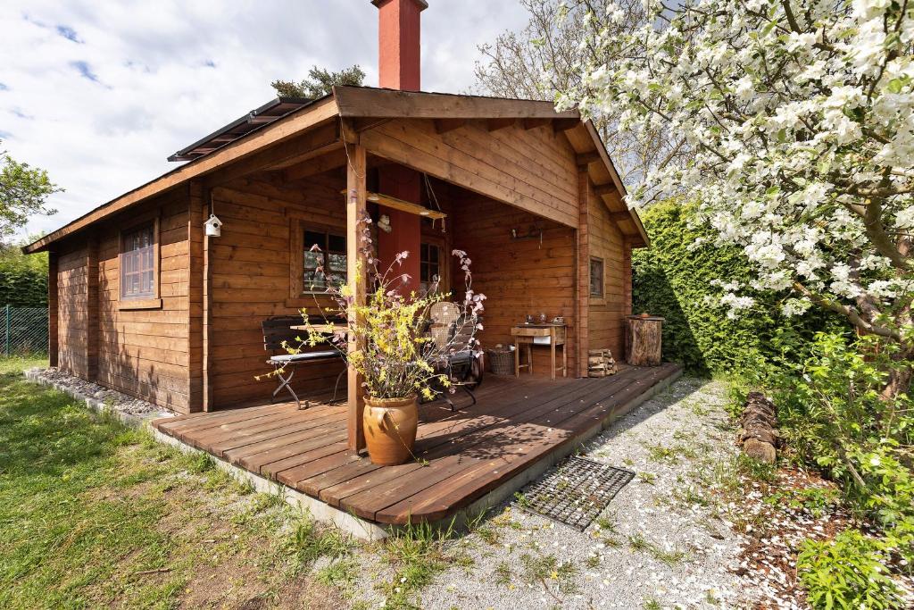 a small wooden cabin with a deck in the yard at Blockhütte in Fürstenwalde