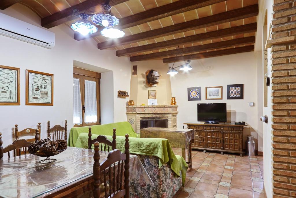 a living room with a table and a television at La Acacia in Martos