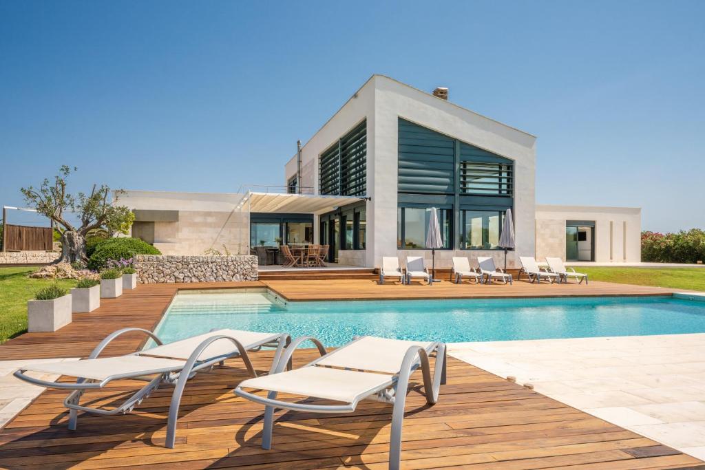 a villa with a swimming pool and a house at Villa Canutells Ref 27 in Mahón
