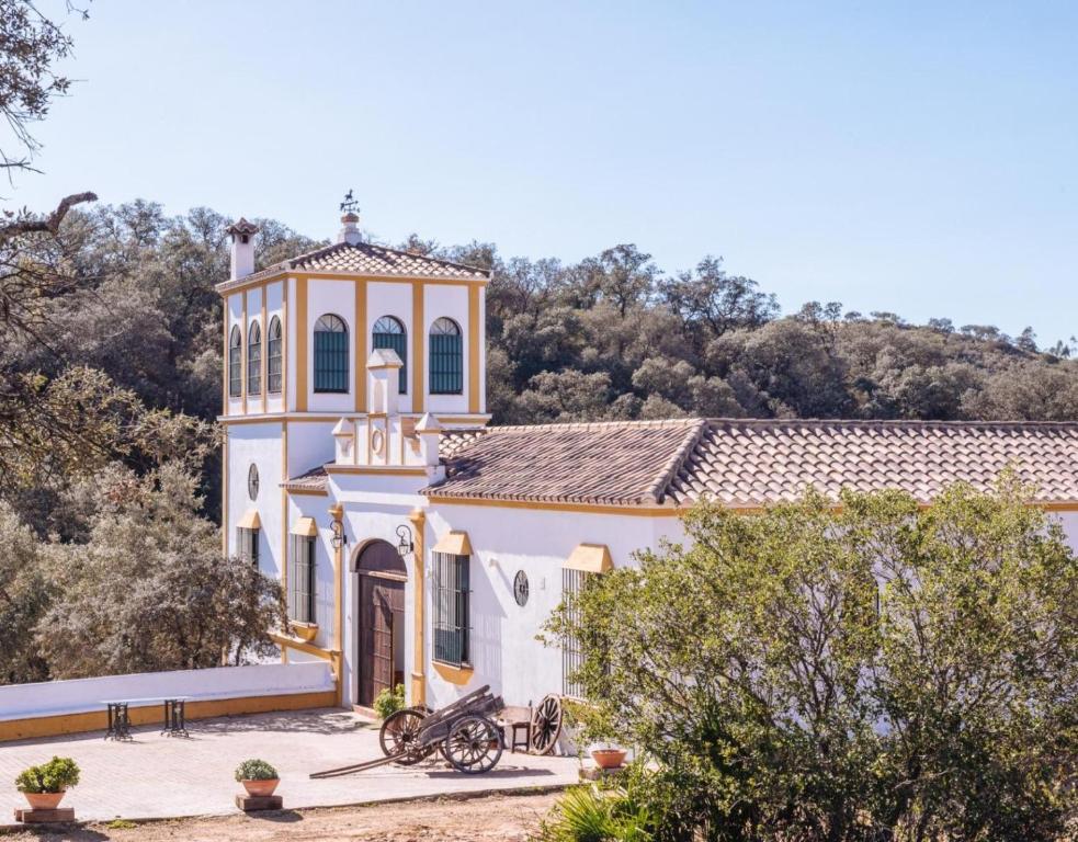 a large white building with a clock tower at Finca Gorriones 25 minutos Sevilla in El Garrobo