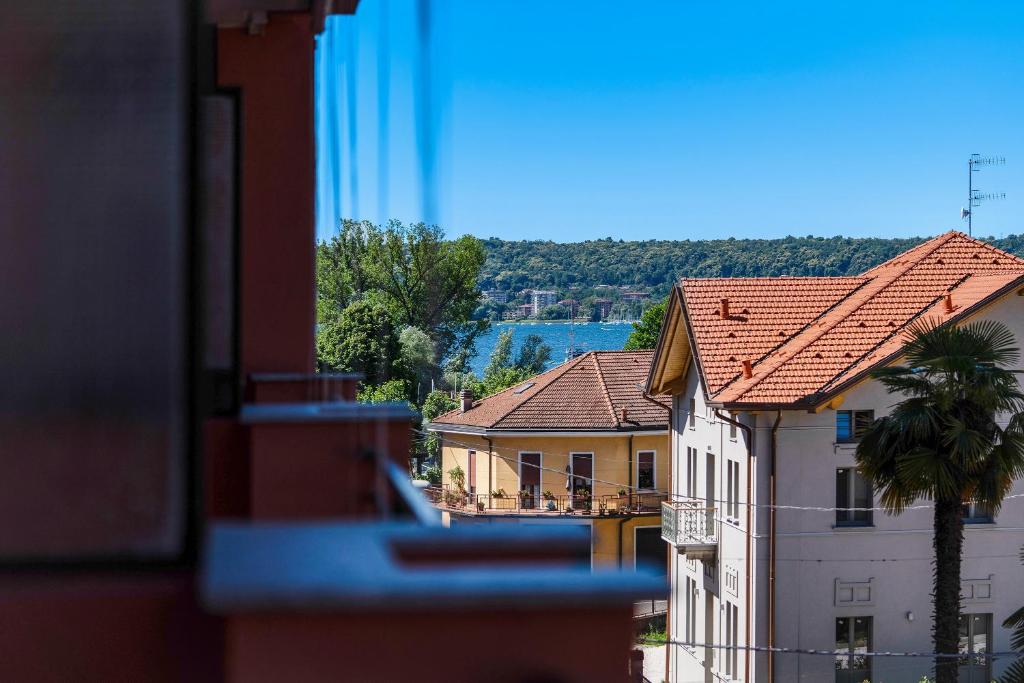 a view of buildings and a palm tree from a window at Iris Apartment Lago Maggiore in Angera