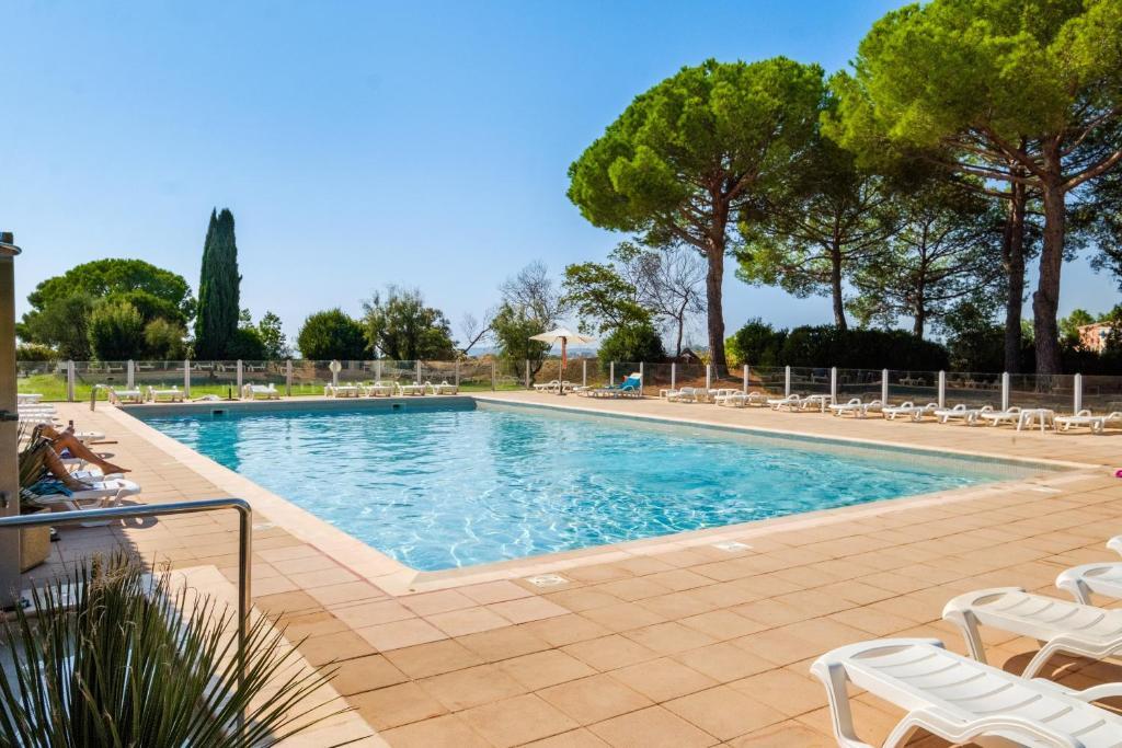 a large swimming pool with chairs and trees at Appartement Vaugrenier Presidences in Villeneuve-Loubet