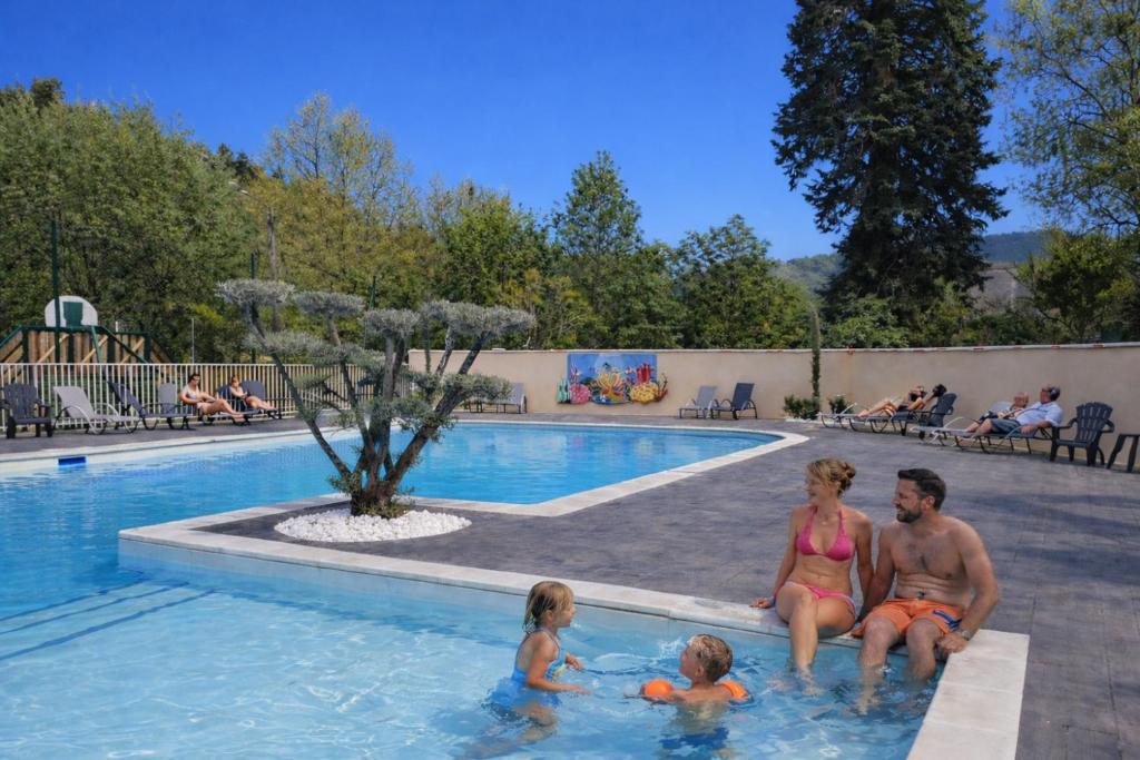 a group of people sitting in a swimming pool at Camping de Retourtour in Lamastre