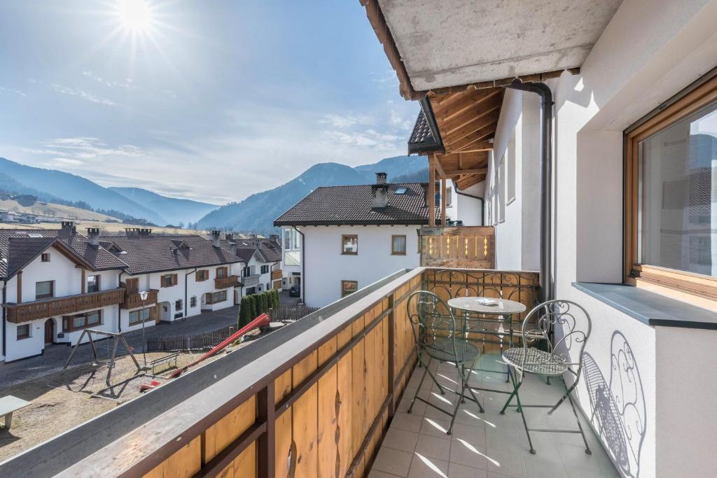 a balcony with chairs and tables and a view of mountains at Trojer Apartment 2 in Sarntal