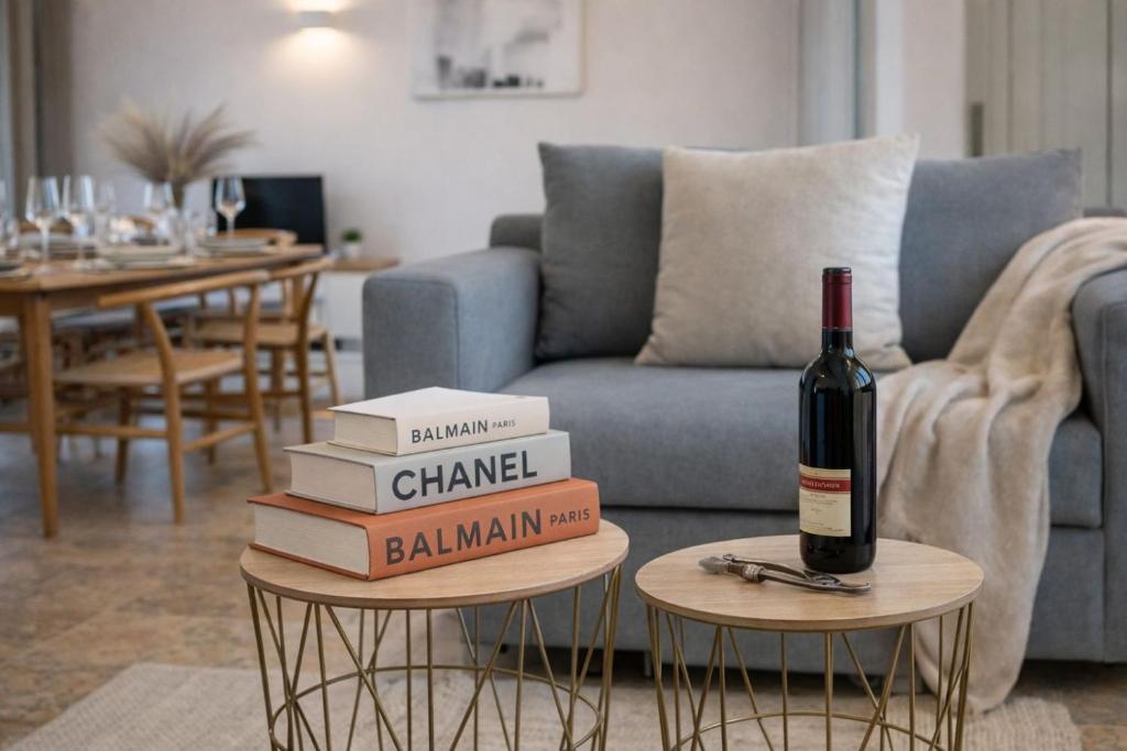 a stack of books and a bottle of wine on two tables at Elysium Living in Gouvia