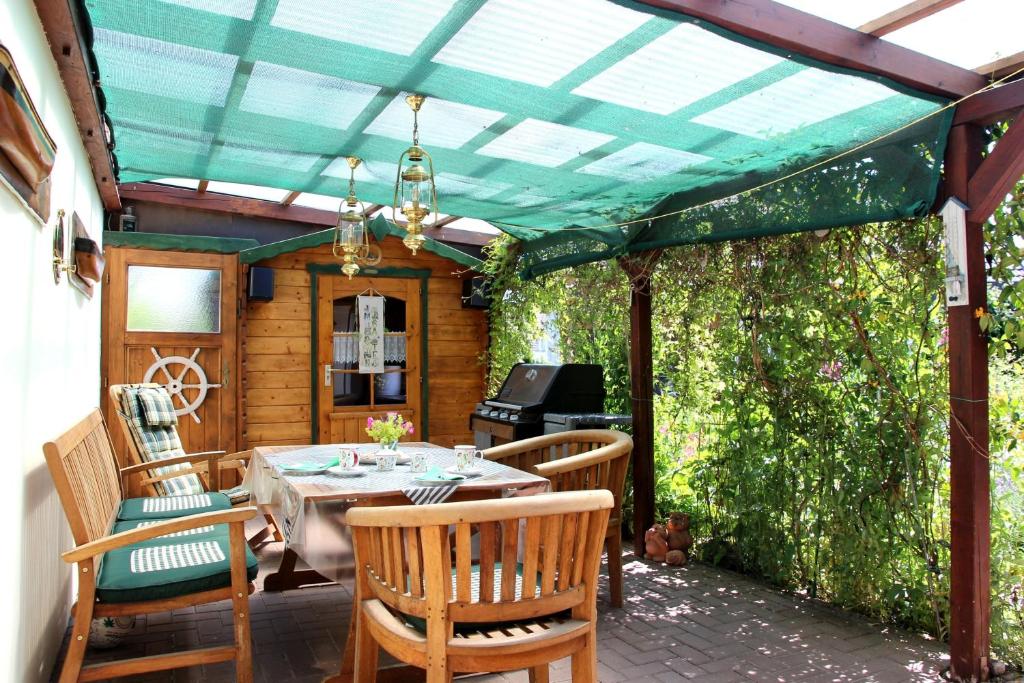 a patio with a table and chairs under a pergola at Ferienoase Balve in Balve