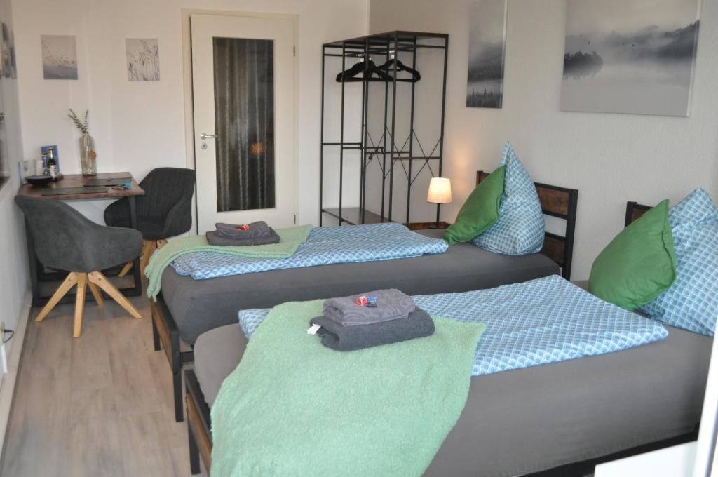 a room with three beds with green and blue at Backbordkajüte am Steinhuder Meer in Wunstorf
