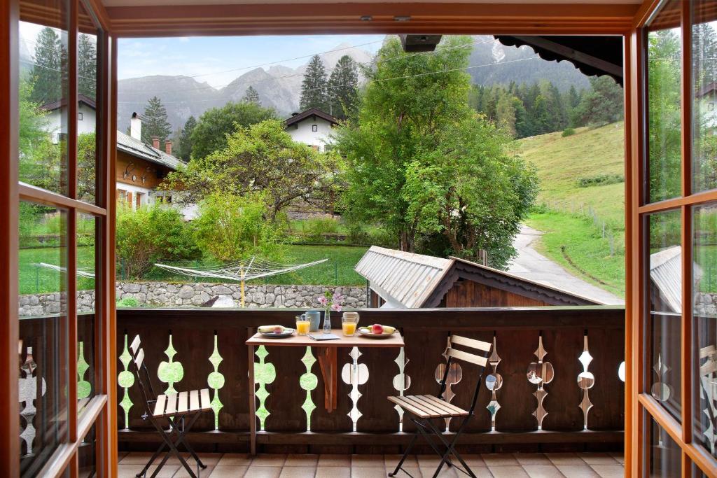 a room with a balcony with a table and chairs at Ferienwohnung Zugspitznest in Grainau