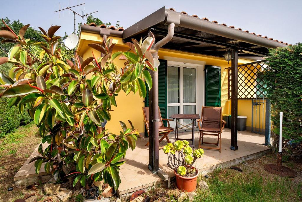 a yellow house with a table and a chair at Villa Pairola - in San Bartolomeo al Mare