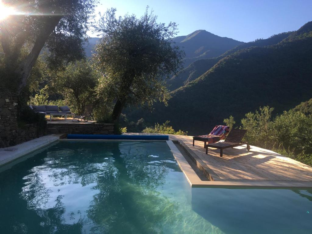 a swimming pool with a chair and a view of mountains at Il wokini in Castel Vittorio