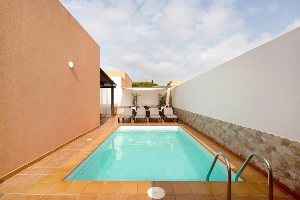a swimming pool in the middle of a house at El Cortijo in La Oliva