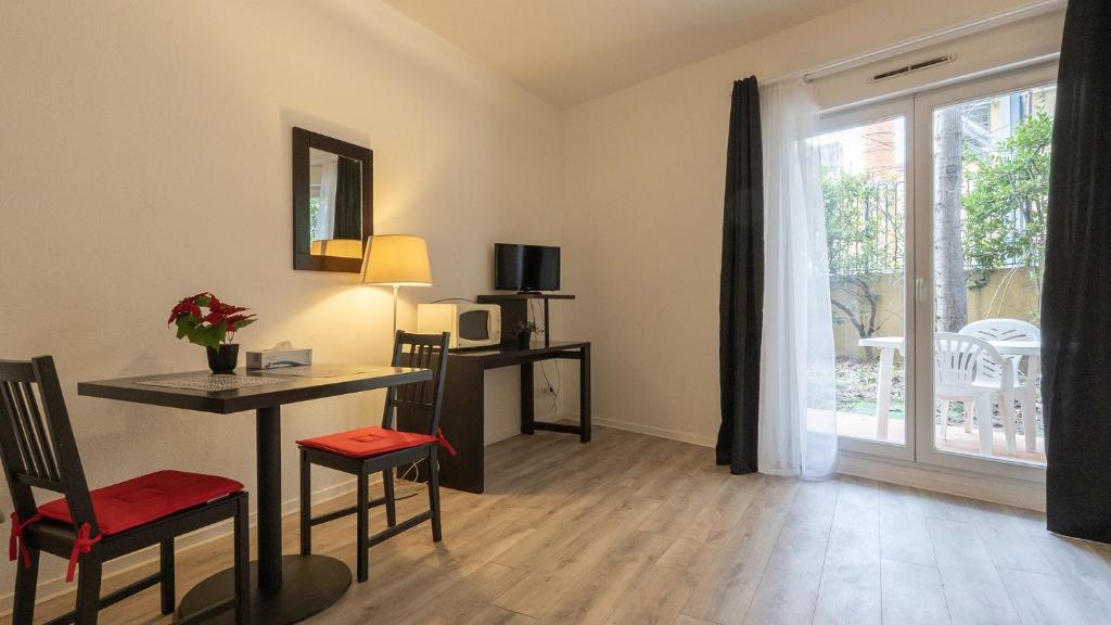 a living room with a table and chairs and a window at Virginia N104 - ST2 in Grasse