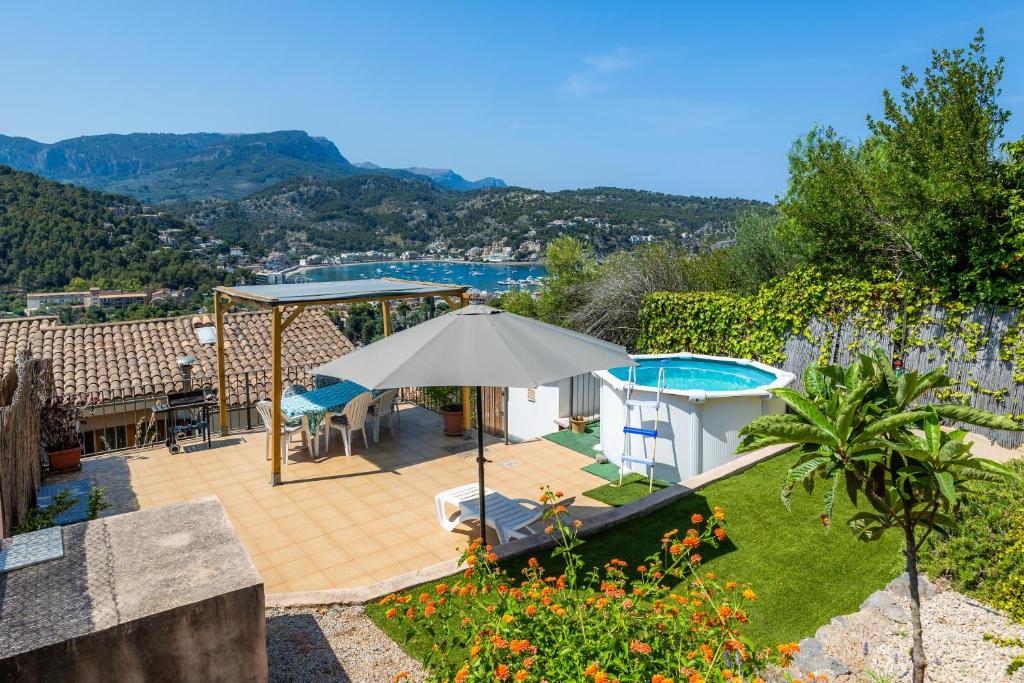 a patio with an umbrella and a swimming pool at Sa Torreta Luxury Views 3 Bedrooms in Sóller