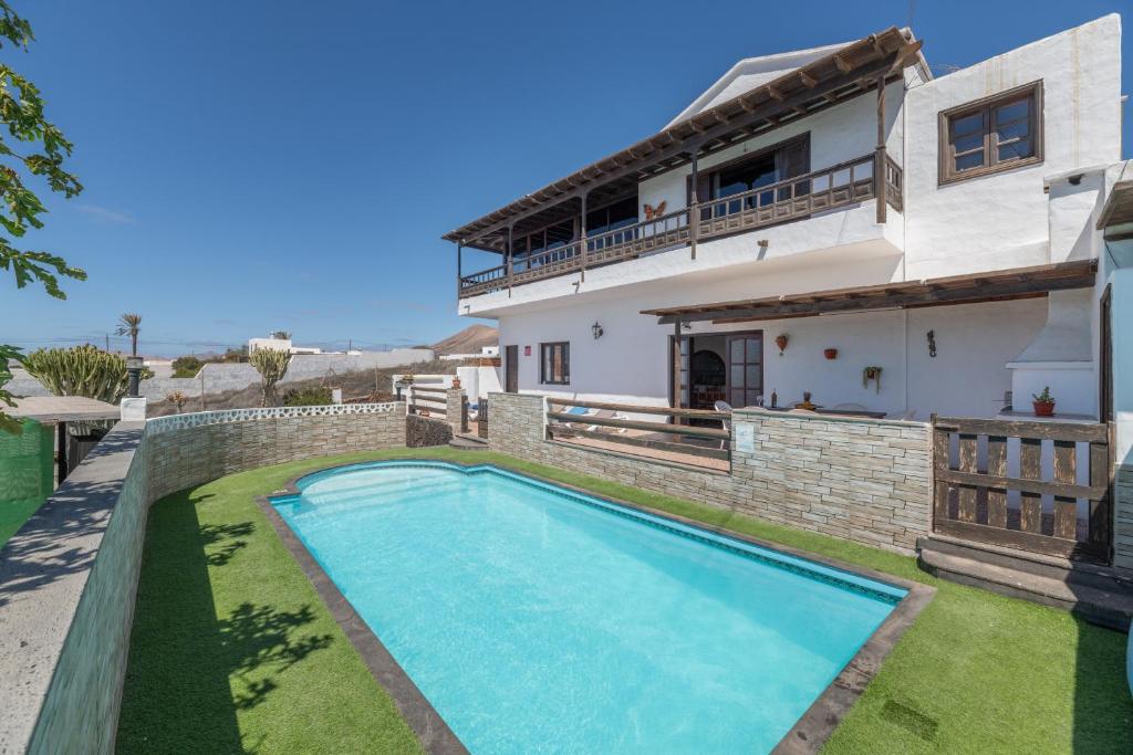 a villa with a swimming pool in front of a house at Andres House, Tías in Tías