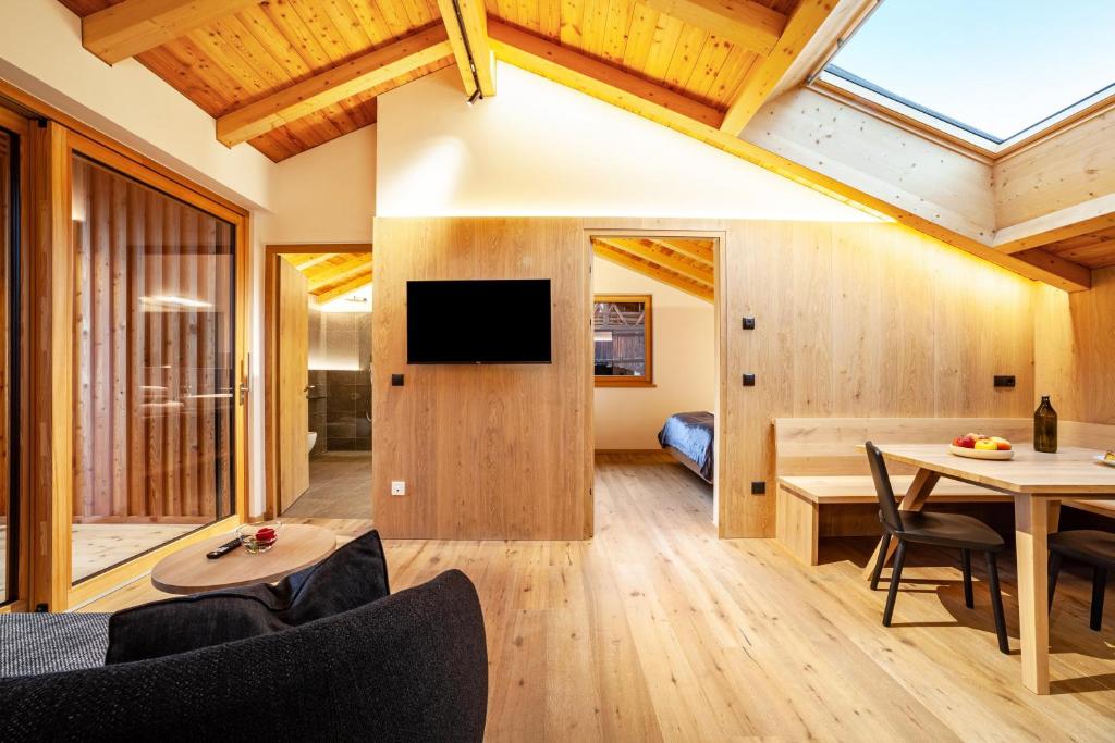 a living room with wooden walls and a large window at Huetterhof Apartement Herbischt in Caines