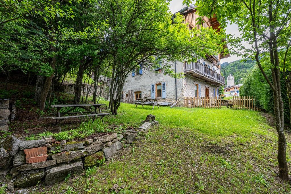 a stone house with a picnic table and trees at Les Chalets de la Revue in Flumet