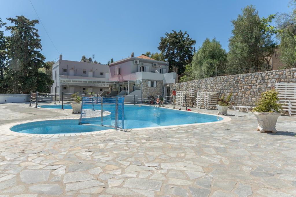a swimming pool in front of a house at Ilias Voula Studios in Kalymnos