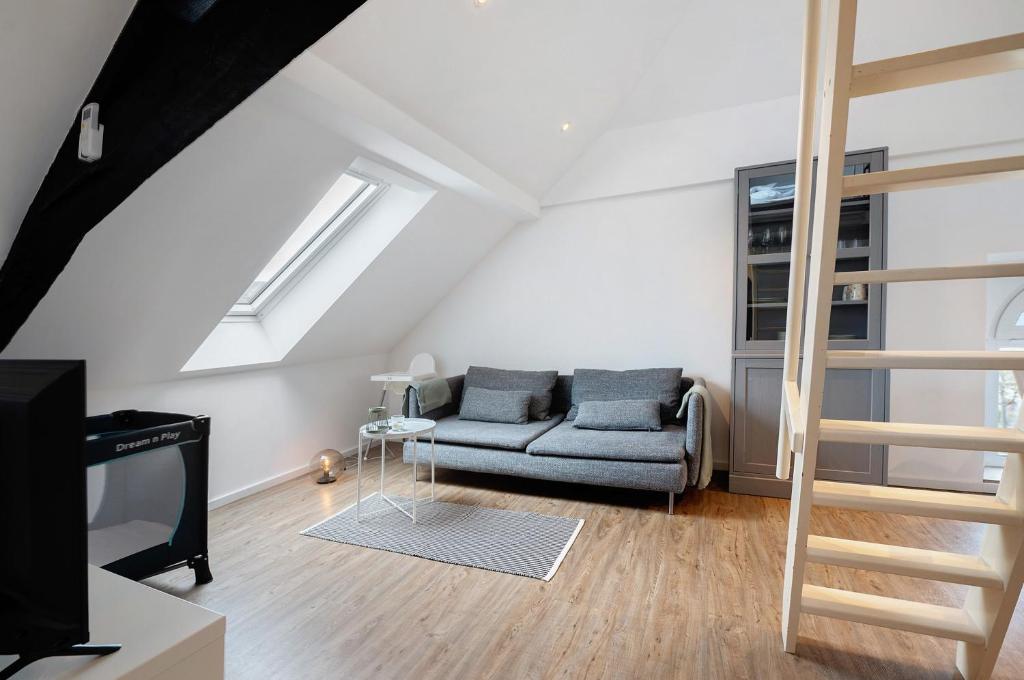 a living room with a couch and a tv at Adlernest mit Weinbergblick in Trittenheim